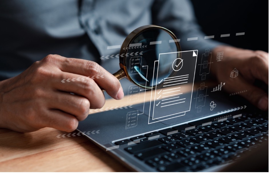 A person looking at a computer with a magnifying glass